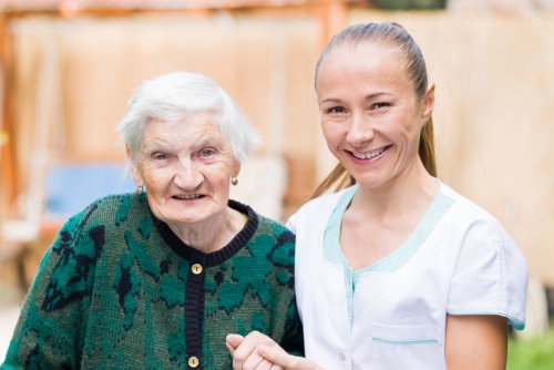 smiling caregiver and her old patient